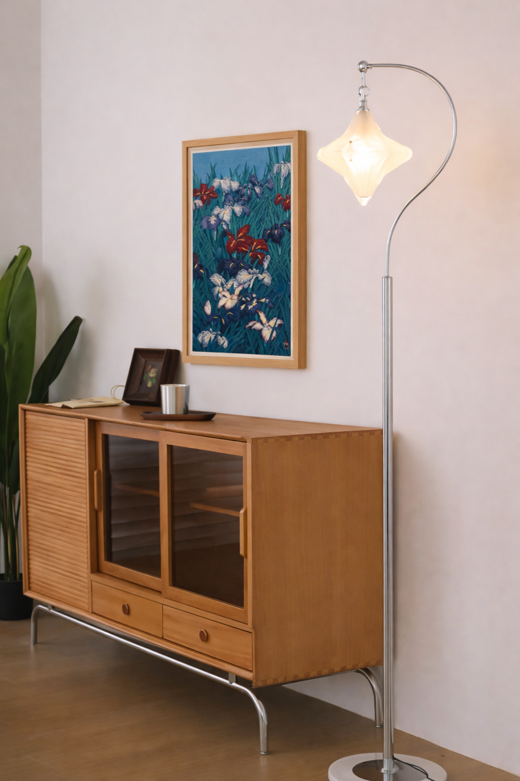 Wooden sideboard with a lamp and framed artwork in a room.
